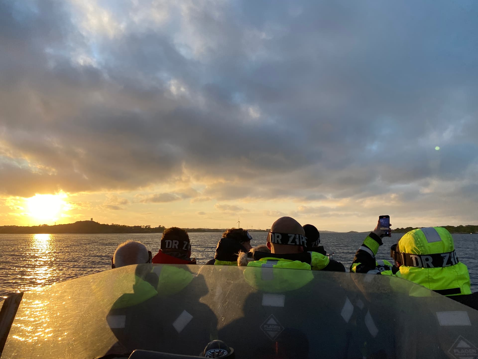 Sällskap i RIB-båt på väg mot solnedgången i Göteborgs skärgård